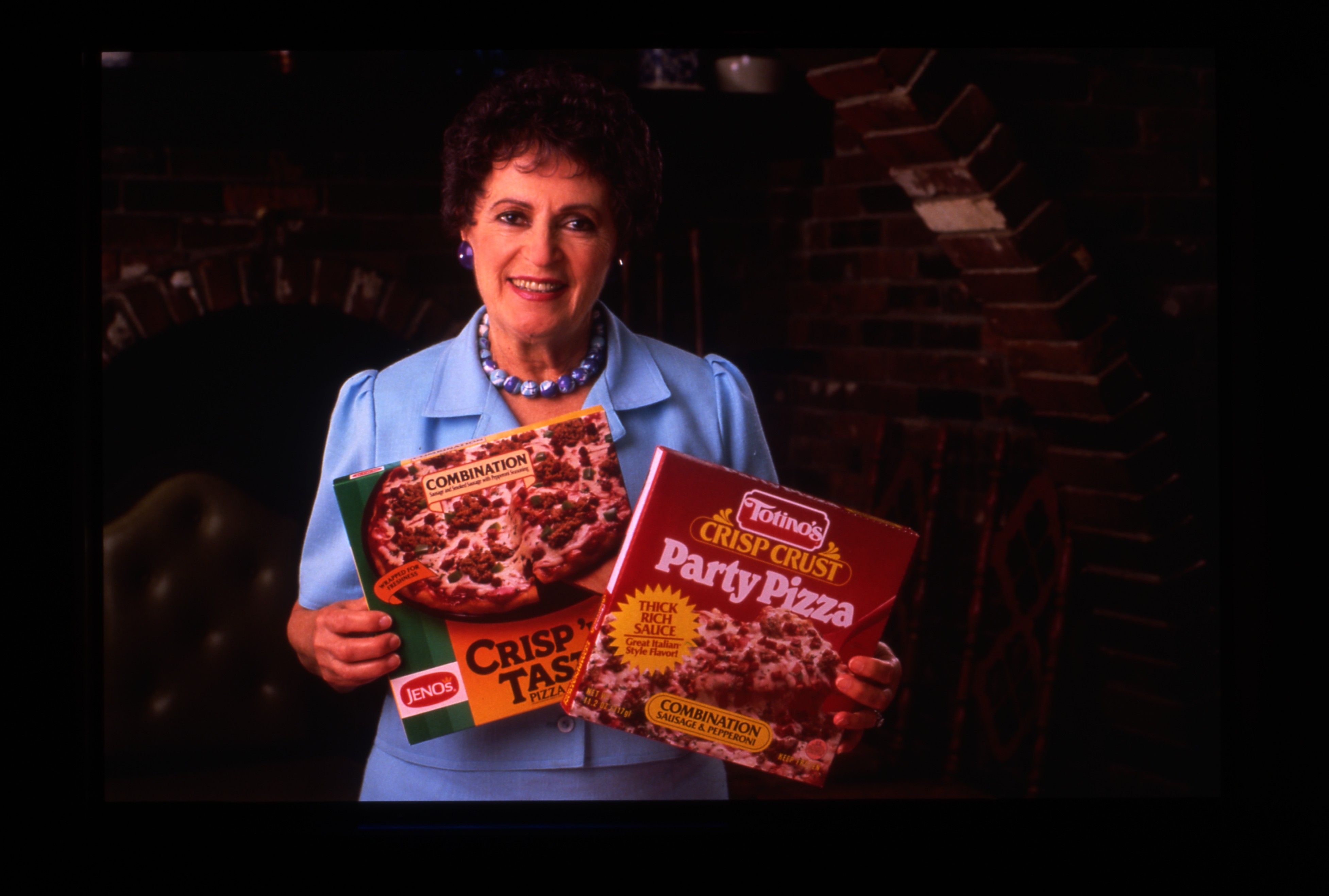 Rose Totino holding some Jeno's and Totino's pizzas