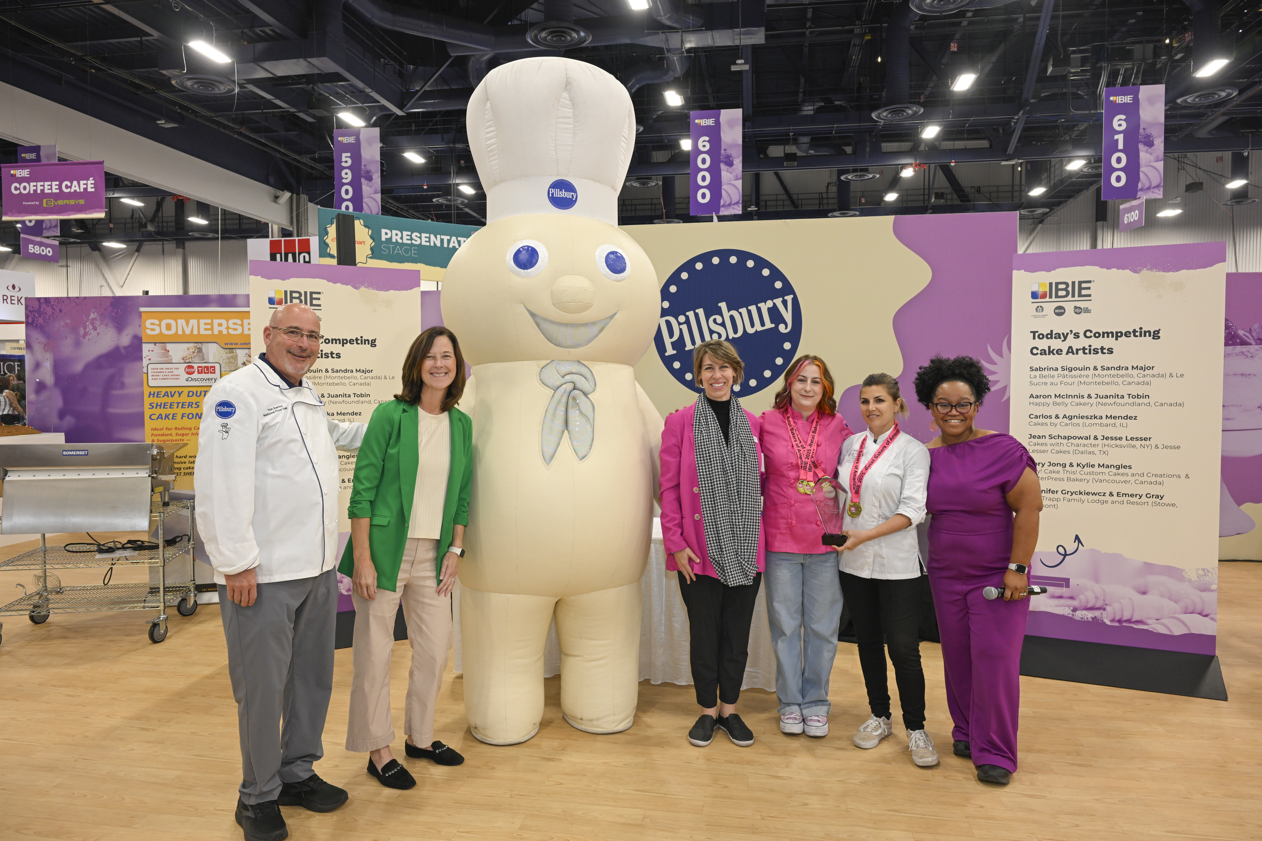 Team photo gathered near the Pillsbury Doughboy mascot